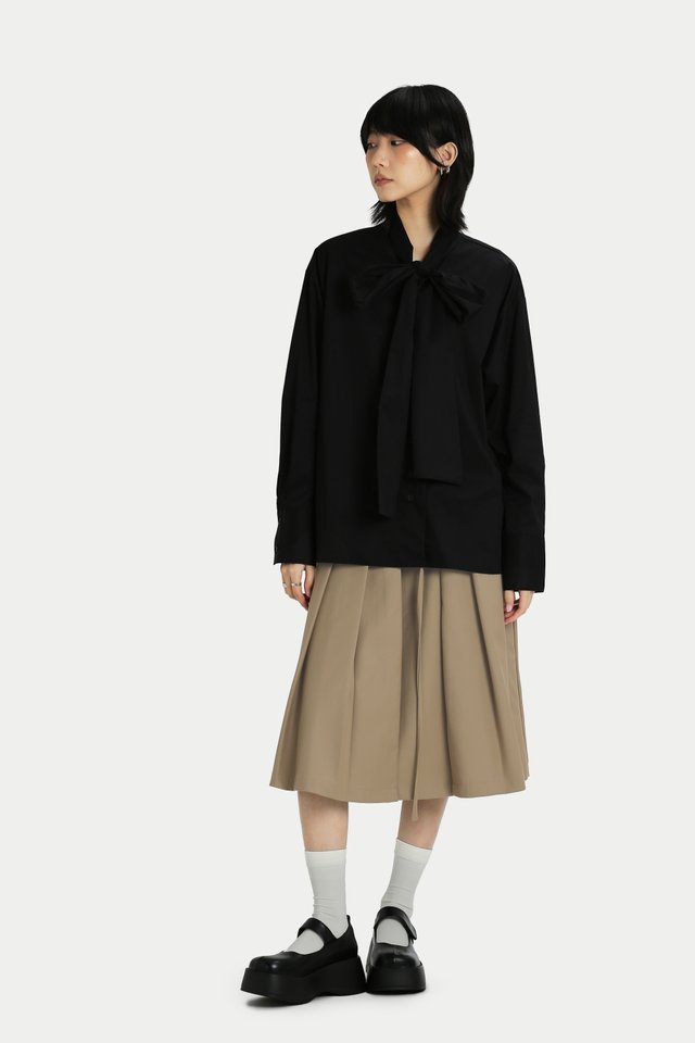 RUMI FRONT BUCKLE PLEATED SKIRT IN SAND