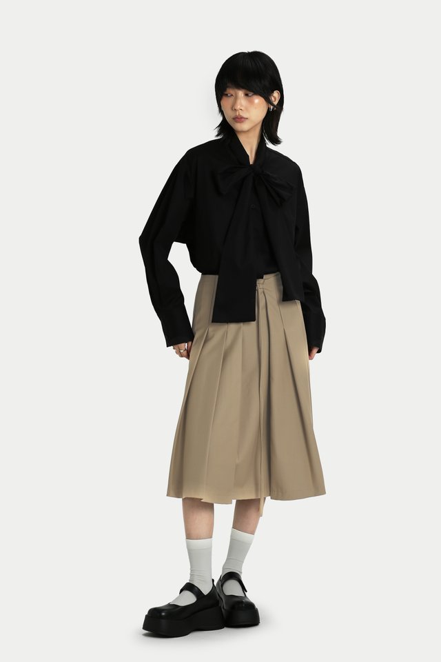 RUMI FRONT BUCKLE PLEATED SKIRT IN SAND
